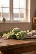 Green soy candle flowers on a textured beige background
